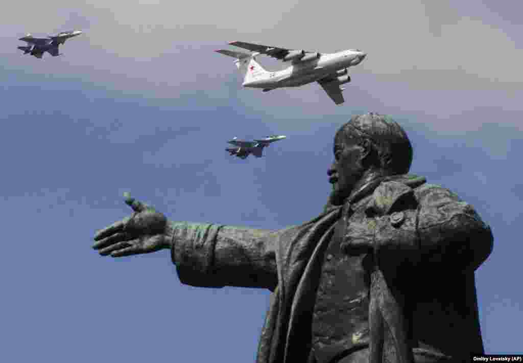 Military planes fly above a statue of Soviet Union founder Vladimir Lenin during a Naval parade rehearsal in St. Petersburg. (AP/Dmitri Lovetsky)