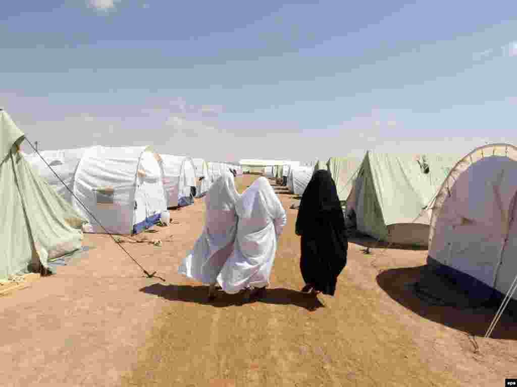 Refugees who fled the violence in Libya walk at the newly opened refugee camp for Libyan families in Ramada, some 25 kilometers from the Tunisian-Libyan border, on May 10. UN aid agencies have appealed to the EU and NATO to increase their efforts to rescue refugees crossing the Mediterranean Sea from Libya in unsafe boats. Photo by Mohamed Messara for epa