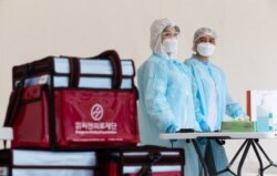 Медицинские сотрудники в пункте для сдачи анализов на коронавирусную инфекцию. Алматы, 14 мая 2020 года