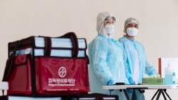 Медицинские сотрудники в пункте для сдачи анализов на коронавирусную инфекцию в Алматы.