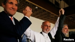 U.S. Secretary of State John Kerry (L) and Afghanistan's presidential candidates Ashraf Ghani Ahmadzai (C) and Abdullah Abdullah hold their arms in the air together after announcing a deal for the auditing of all Afghan election votes earlier this summer. (file photo)