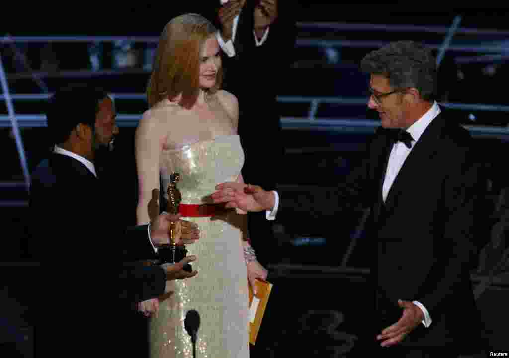 Actors Chiwetel Ejiofar and Nicole Kidman present director Pawel Pawlikowski (right) with the Oscar for best foreign language film Ida. Filmed in black and white, Ida tells the story of a novice in 1960s Poland who must decide whether to take her vows and become a nun - after learning that her family were Jews.