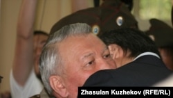 A relative bids goodbye to Zhaksylyk Doskaliev (facing camera), the former Kazakh health minister who was sentenced to seven years in prison on a corruption charge.