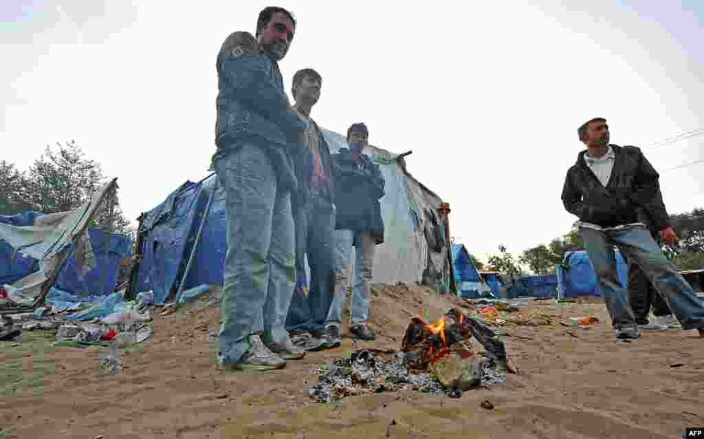 Francuska - Emigranti - Grupa emigranata, najvećim dijelom iz Afganistana, grije se pored vatre u Calaisu, na sjeveru Francuske. Želja im je domoći se Engleske. Francuska vlada je najavaila zatvaranje ove, kako su je nazvali ¨džungle¨u Calaisu. 