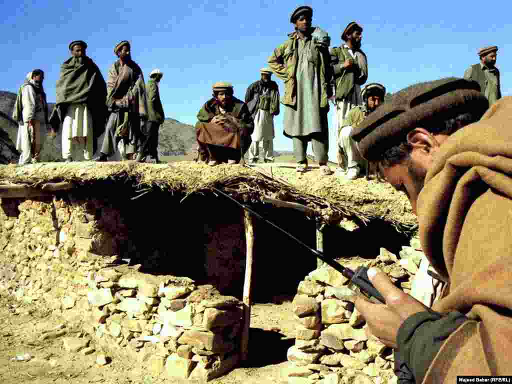 Afghan fighters outside one of the entrances to caves where Osama bin Laden was reportedly hiding in the mountains of Tora Bora in December 2001.