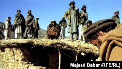 FILE: Afghan fighters outside one of the entrances to caves where Saudi terrorist Osama bin Laden was reportedly hiding along hundreds of Arab Al-Qaeda fighters in the mountains of Tora Bora in eastern Afghanistan in 2001. 