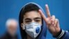 An Iranian boy gestures as he wears protective mask to prevent contracting a coronavirus in Tehran, February 20, 2020