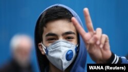 An Iranian boy gestures as he wears protective mask to prevent contracting a coronavirus in Tehran, February 20, 2020