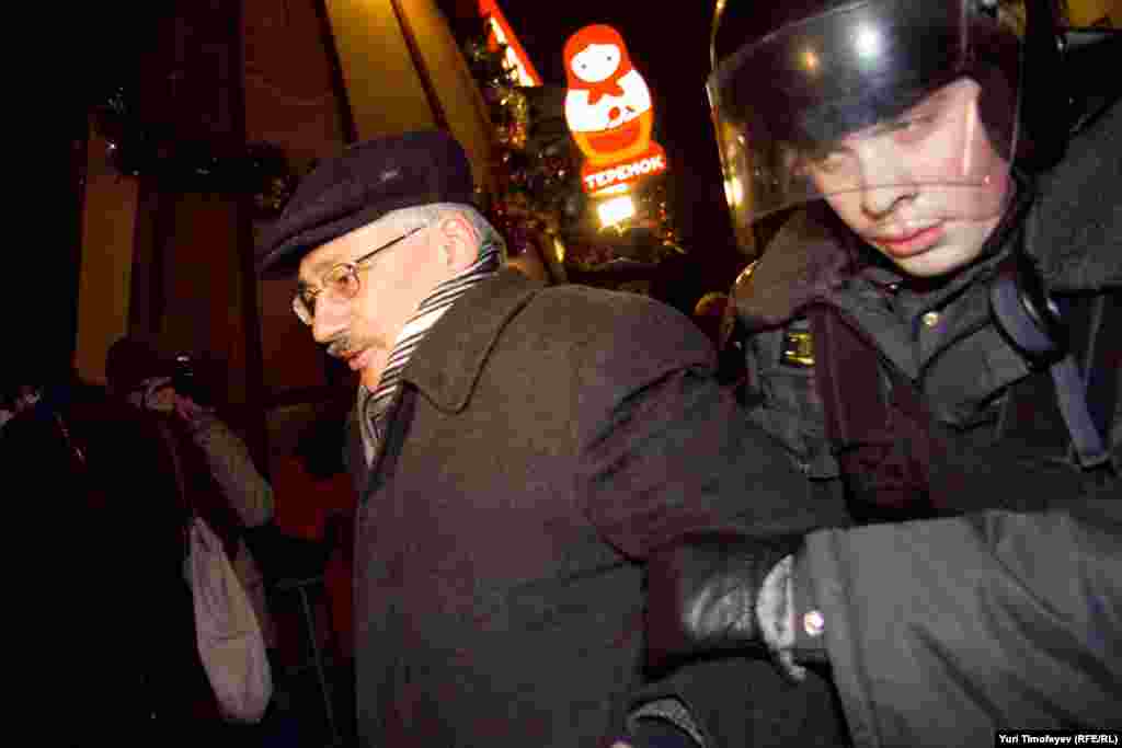 Police detain Oleg Orlov, the head of the Moscow-based Memorial human rights group, during a rally to protest the results of the parliamentary elections.