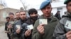 Afghan men wait for to enter a polling center and cast their votes in presidential and provincial-council elections in Kabul on April 5.