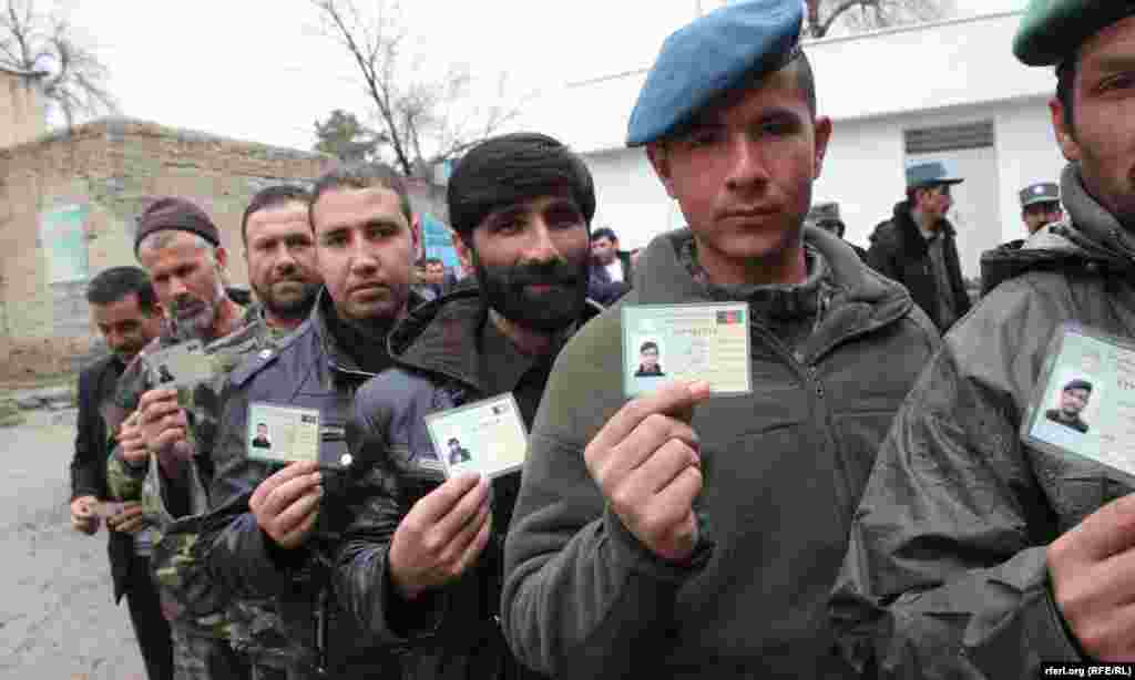 Afghan men wait for to enter a polling center and cast their votes in presidential and provincial-council elections in Kabul on April 5.