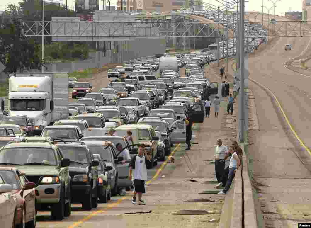 Drivers and passengers wait outside their vehicles during a massive traffic jam as travelers try to leave downtown New Orleans on August 28. Authorities had ordered hundreds of thousands of residents to leave vulnerable areas before the hurricane hit. Many were unable to do so.