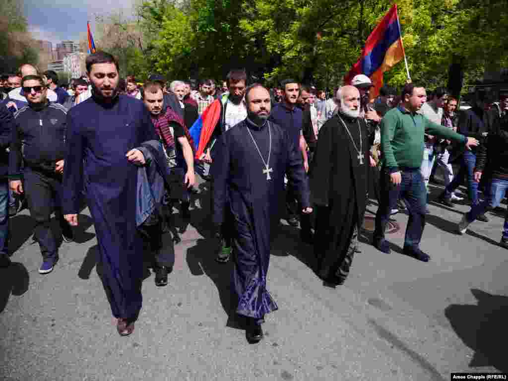 Four priests lead marching opposition protesters in Yerevan.