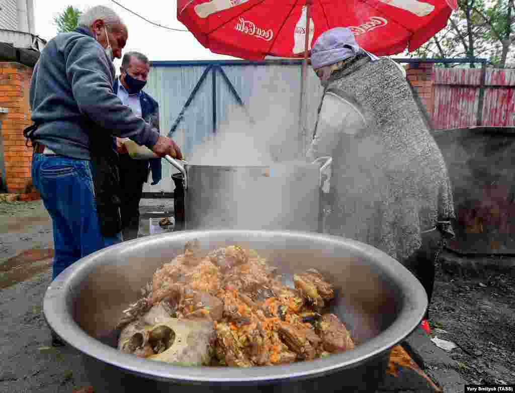 Cooks prepare pilaf on May 18 at an immigrant-detention center in the eastern Russian city of Artem ahead of the Muslim feast of Eid al-Fitr.