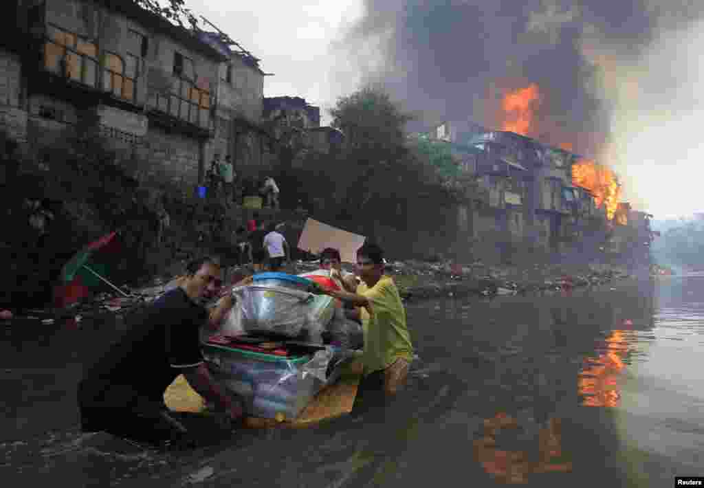 Residents salvage their belongings after a raging fire engulfed around 2,000 houses in the metro Manila area in the Philippines. At least eight people, including a 7-year-old child, died and thousands were displaced. (Reuters/Romeo Ranoco)