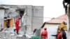 ALBANIA -- Emergency personnel walk over debris of collapsed and damaged buildings following Tuesday's powerful earthquake in Thumane, Albania, November 27, 2019