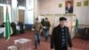 People cast their ballots in front of a portrait of President Gurbanguly Berdymukhamedov at a polling station in Ashgabat on December 15. 