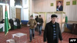 People cast their ballots in front of a portrait of President Gurbanguly Berdymukhamedov at a polling station in Ashgabat on December 15. 