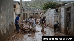 Men clear away mud following floods in the Iranian city of Mamulan in Lorestan Province on April 7.