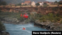 Një helikopter duke marrë ujë prej lumit Moraça për t’i shuar zjarret rreth Podgoricës.