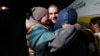 A Ukrainian prisoner of war embraces his relatives after a swap at an undisclosed location in Ukraine on October 18.