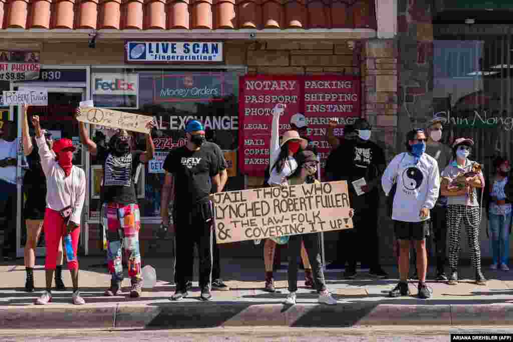 Protesters hold up placards as they gather on Palmdale Blvd demanding justice for Robert Fuller, a young black man who was found hanging from a tree, on June 16, 2020, in Palmdale, California. Los Angeles County Sheriff Alex Villanueva on June 16 pledged a "thorough" investigation into the death of Fuller, a black 24-year-old man found hanging from a tree in Palmdale, southern California. Fuller's family has cast doubt on the possibility he would take his own life and has urged a full investigation. Questions have also been raised following the death last month of another black man about 50 miles east of Palmdale.