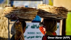 Afghan girls selling bread at a market in Badakhshan Province in November 2024. (AFP)