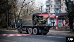 A military truck carries what appears to be an antiaircraft gun through the streets of Donetsk on November 2.