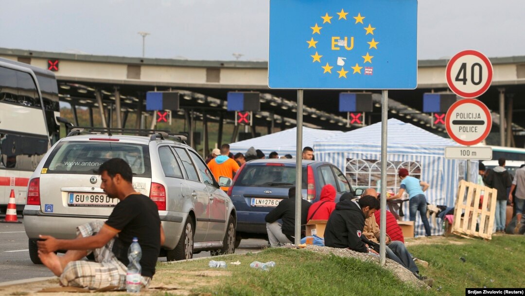 Migrants gather near a European Union sign at the Croatia-Slovenia border crossing at Bregana, Croatia, on September 19.
