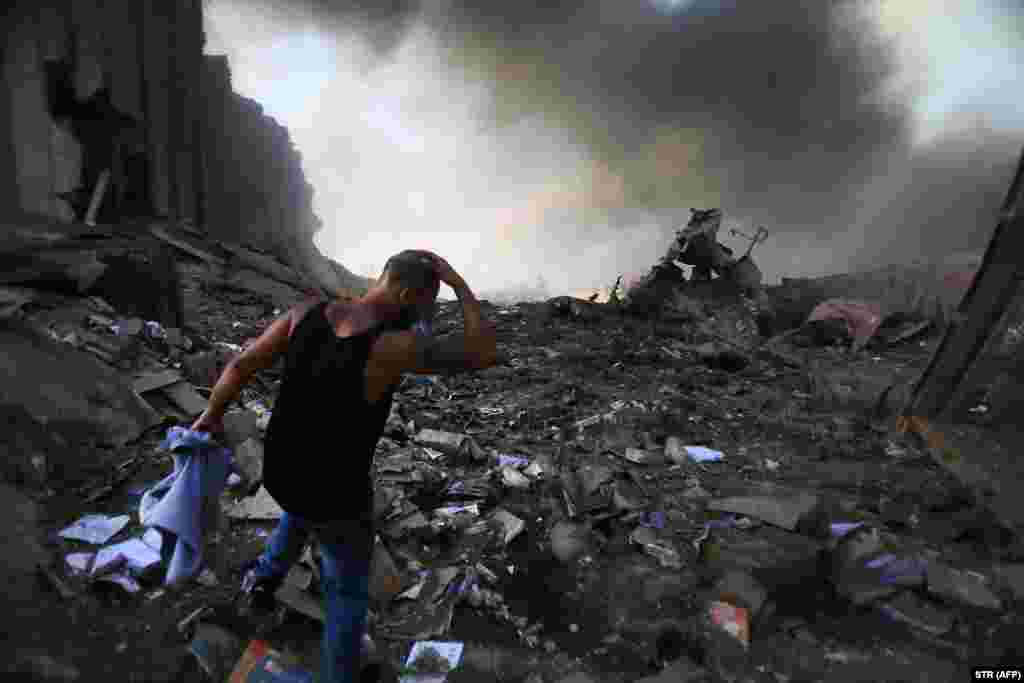 Жител на Бејрут на урнатини од зграда по експлозиите&nbsp;