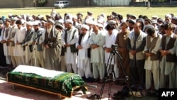 Mourners pray near the body of Amanullah Aman, head of the Independent Election Commission (IEC) in Konduz, on September 19, after he was killed by the Taliban.