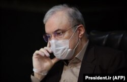 Iranian Health Minister Saeed Namaki wears a protective mask during a cabinet session in the capital Tehran, March 25, 2020