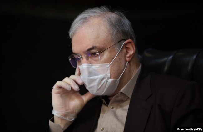 Iranian Health Minister Saeed Namaki wears a protective mask during a cabinet session in the capital Tehran, March 25, 2020