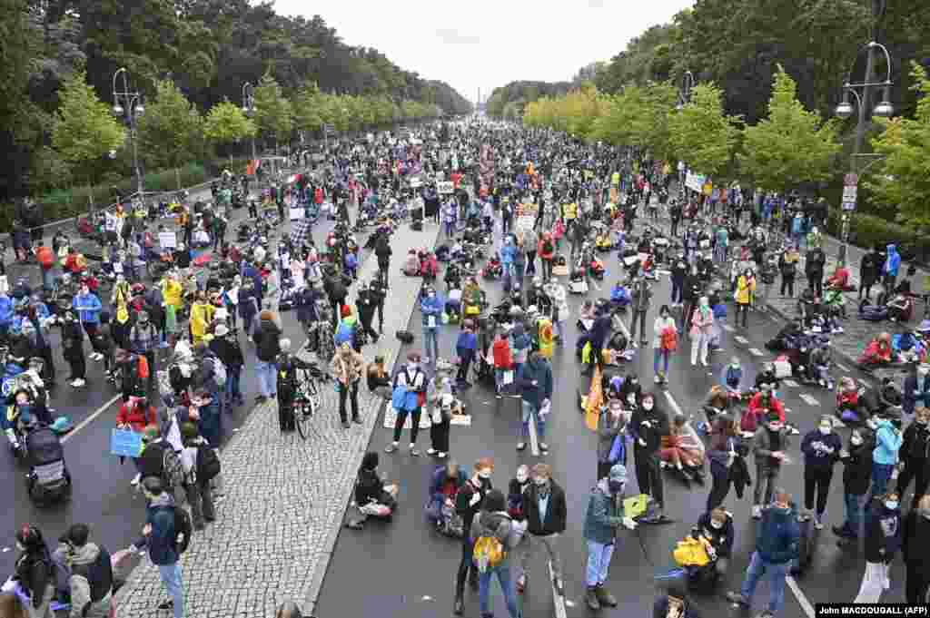 Demonstrators stand and sit along the 17th June street in front of the Brandenburg Gate during a demonstration of the climate activists from the &quot;Fridays for Future&quot; movement, on September 25, 2020, in Berlin.
