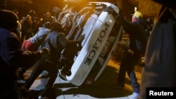 Pamje nga protesta të U.S. -- Protesters flip over a Ferguson police car in Ferguson, Missouri, November 25, 2014