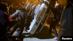 Демонстранттар полиция унаасын оодарууда. Фергюсон, 25-ноябрь, 2014-жыл. 