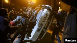 Протестувальники перегортають поліцейську машину, Фергюсон, США, 25 листопада 2014 року