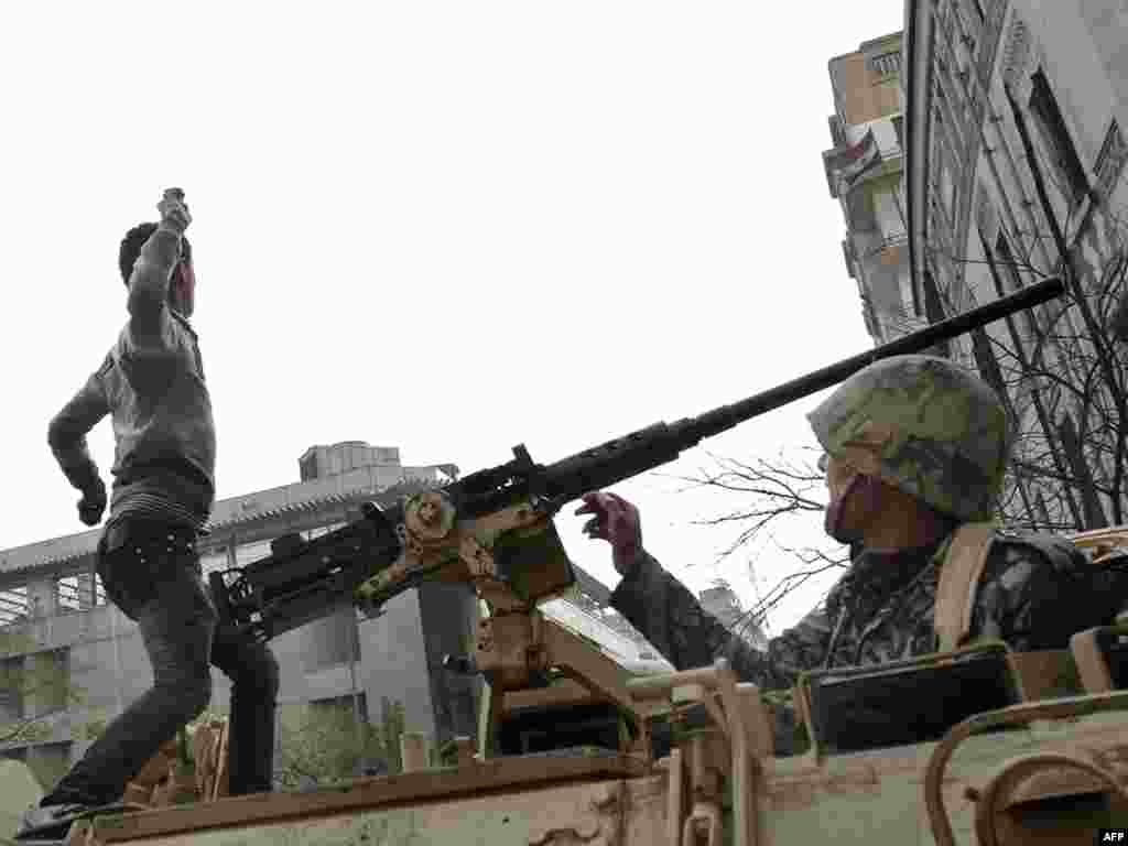 A demonstrator throws a stone from atop an armored vehicle in central Cairo on January 29.