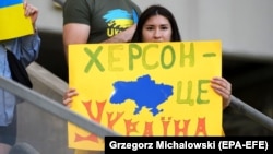 Українська вболівальниця з плакатом «Херсон – це Україна» перед матчем Ліги націй УЄФА між Україною і Вірменією. Лодзь, Польща, 11 червня 2022 року