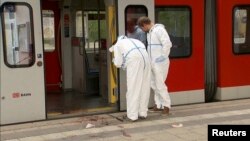 Germany -- Police investigators looks at bloodstained footprints leading out of a train and on a platform following a knife attack in Grafing train station, south east of Munich, May 10, 2016