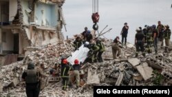 Спасатели извлекают тело из завалов, город Часов Яр в Донецкой области, 10 июля 2022 года