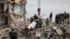 Ekipet e shpëtimit duke nxjerr një trup nga rrënojat e ndërtesës së shktërruar në Çasiv Jar. 