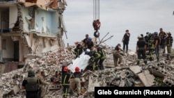 Спасатели извлекают тело из-под завалов, город Часов Яр в Донецкой области, 10 июля 2022 года