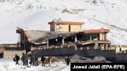 Afghan intelligence officers leave the collapsed building of the military base following an attack in Maidan Wardak on January 21.
