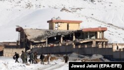 Afghan intelligence officers leave the collapsed building of Afghanistan's intelligence office following an attack in Wardak on January 21.