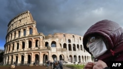 Italy - A man wearing a protective mask passes by the Coliseum in Rome on March 7, 2020