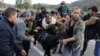 Migranti pomažu ženi koja je dobila ozljede tijekom intervencije hrvatskih policajaca na hrvatsko-bosanskohercegovačkoj granici, 24. listopada