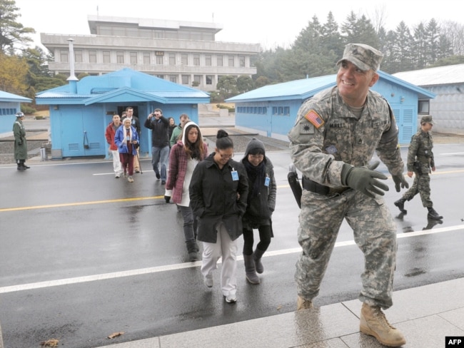 Një ushtar amerikan i prin një grupi turistësh në fshatin e armëpushimit, Panmunjom, në zonën e çmilitarizuar, e cila ndan Korenë e Jugut me atë të Veriut.