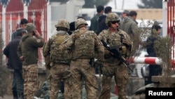 U.S. troops stand guard at the site of a suicide attack in Kabul on February 20.