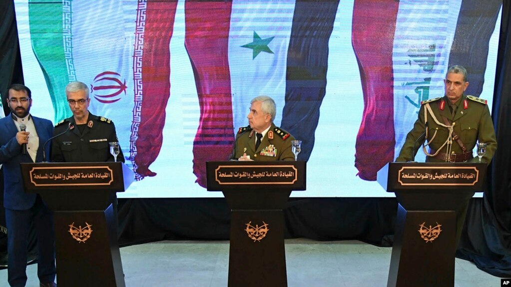  Iran's Chief of Staff of Armed Forces, Maj. Gen. Mohammad Hossein Bagheri, left, speaks during a press conference with Syria's defense minister Gen. Ali Ayoub, center, and Iraqi army commander, Gen. Osman Ghanemi in Damascus, Syria, Monday, March 18, 201